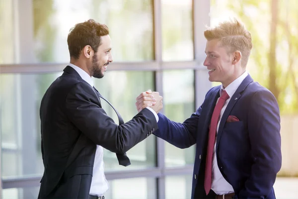 Dois empresários sorrindo e apertando as mãos — Fotografia de Stock