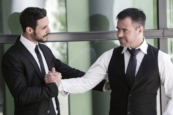 Dois empresários sorrindo e apertando as mãos — Fotografia de Stock