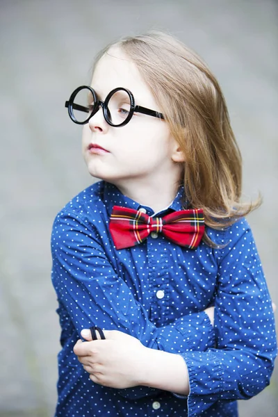 Blond boy with bowtie and huge glasses looking arrogant — Stock Photo, Image