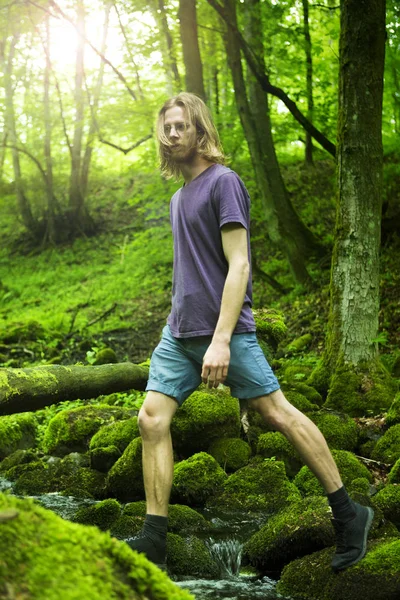 녹색 숲에서 개울을 건너 젊은 남자 — 스톡 사진