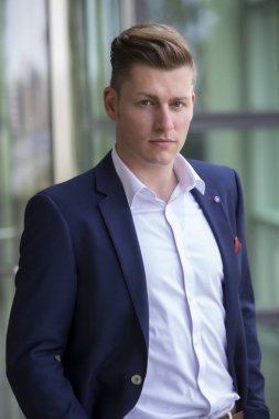 Kameraya bakarak takım elbiseli sarışın adam