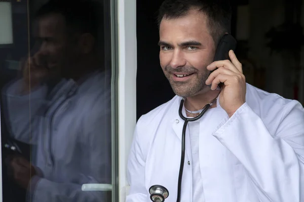 Medico in piedi vicino alla finestra e parlare al telefono — Foto Stock