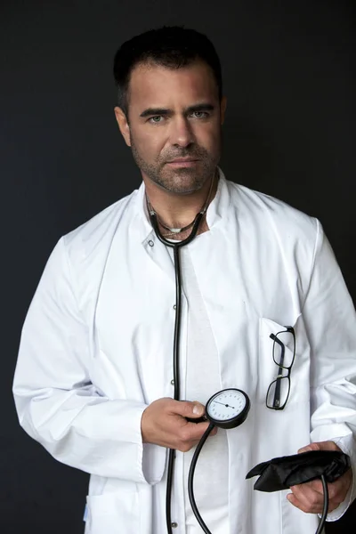 Medico che tiene uno sfigmomanometro e sembra premuroso — Foto Stock