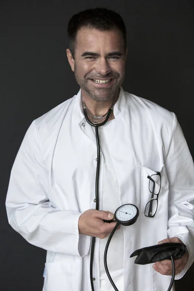 Medico che tiene uno sfigmomanometro e sorride — Foto Stock