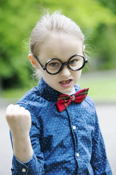 Мальчик в галстуке-бабочке и больших очках показывает кулак — стоковое фото