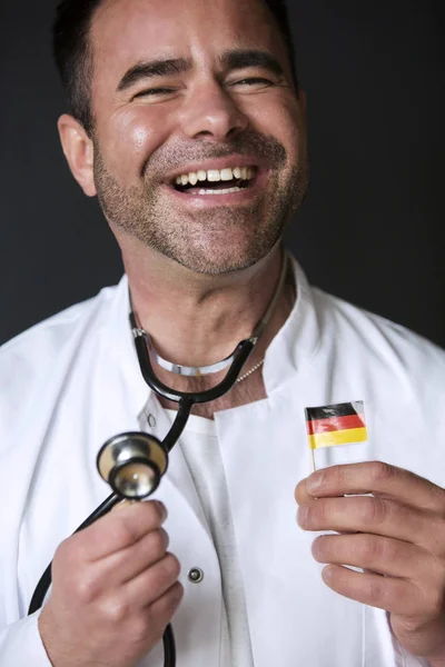 Bel dottore con bandiera tedesca e sorrisi — Foto Stock