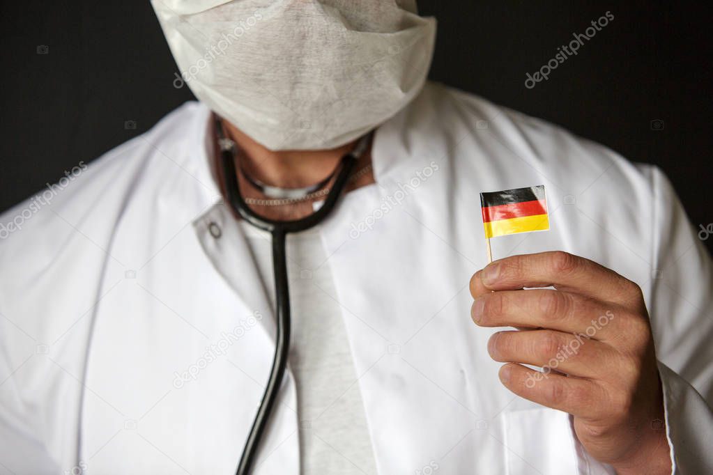 doctor with mouthguard holding a german flag