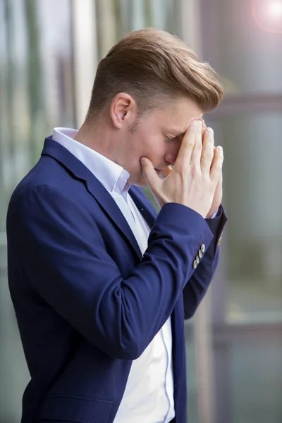 Affärsman står utanför och har huvudvärk — Stockfoto