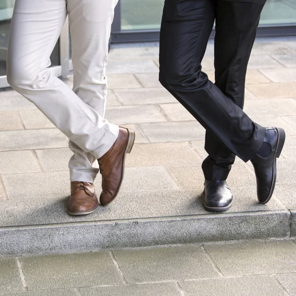 Gros plan des jambes de deux hommes d'affaires debout à l'extérieur — Photo