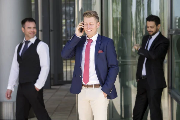 Three smiling businessmen standing outside — Stock Photo, Image