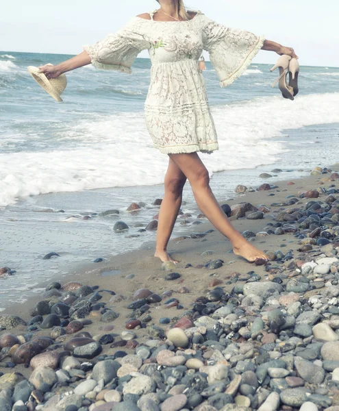 Mujer en vestido blanco caminando descalza en la playa — Foto de Stock