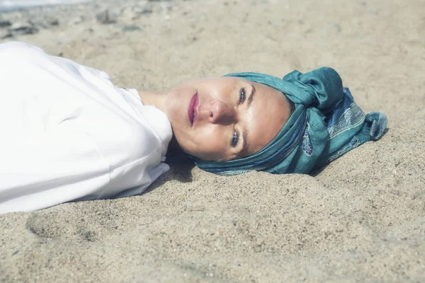 Femme couchée sur la plage et souriant à la caméra — Photo