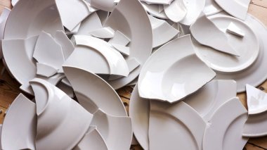white broken plates on a wooden floor clipart