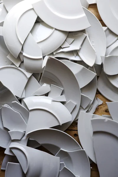 Bílé rozbité talíře na dřevěnou podlahu — Stock fotografie