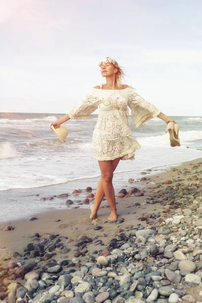Mujer en vestido blanco caminando descalza en la playa — Foto de Stock
