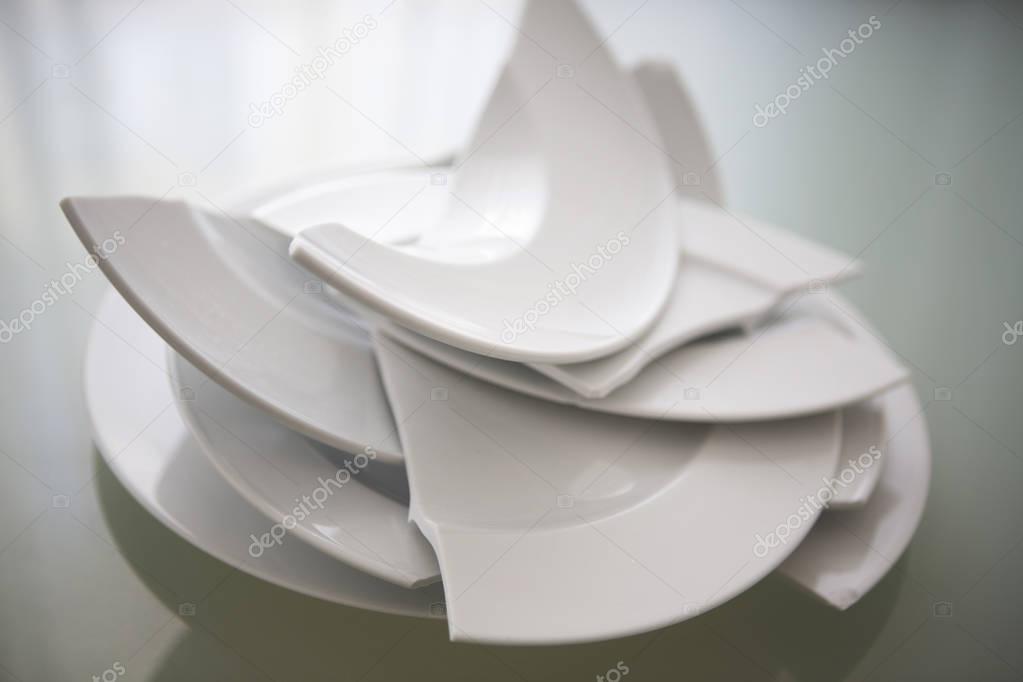 broken white plates on glass table