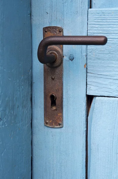 Крупный план голубой двери со старой дверной ручкой — стоковое фото