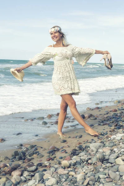 Mujer en vestido blanco caminando descalza en la playa — Foto de Stock