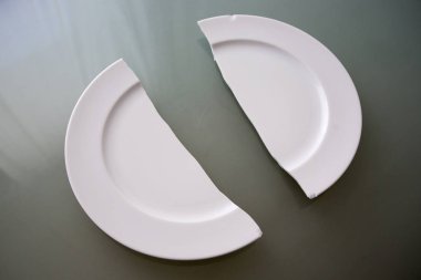 broken white plate on glass table clipart