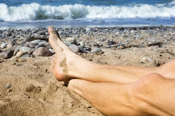Closeup of mans feet lying on the beach — Stock Photo, Image