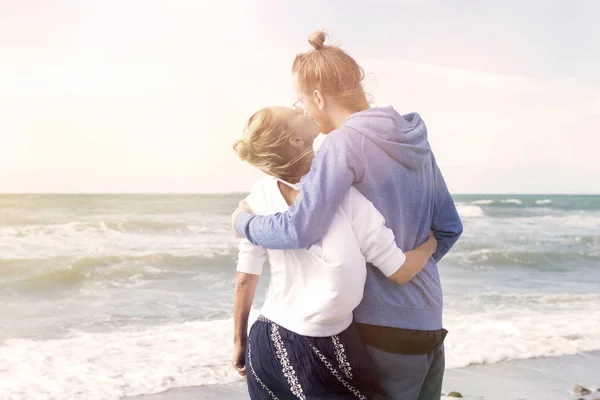 Pareja joven abrazándose unos a otros por el océano — Foto de Stock