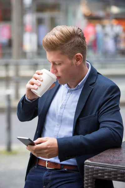 Pohledný blond podnikatel stáli venku drží telefon — Stock fotografie