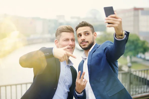 Två stilig affärsmän talar en selfie — Stockfoto