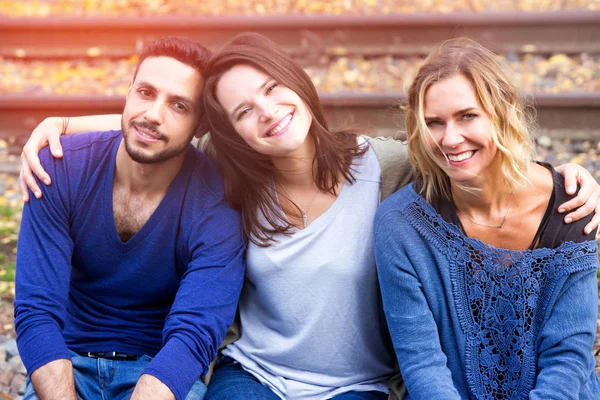 Tre amici seduti sui binari e godersi il sole — Foto Stock