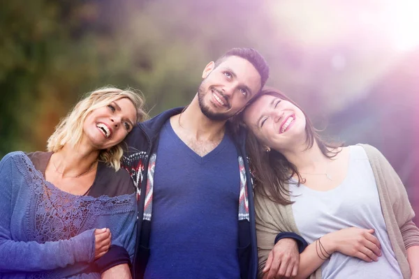 Zwei Frauen und ein Mann gehen und genießen die Sonne — Stockfoto