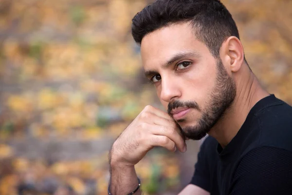 tren rayları üzerinde oturan ve dalgın seyir yakışıklı adam