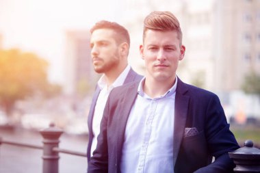 Dışarıda duran ve bekleyen iki genç iş adamları