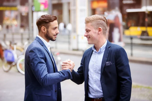 Два бизнесмена приветствуют друг друга на улице — стоковое фото