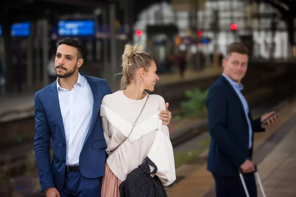 Пара на вокзале и женщина флиртует с другим мужчиной — стоковое фото