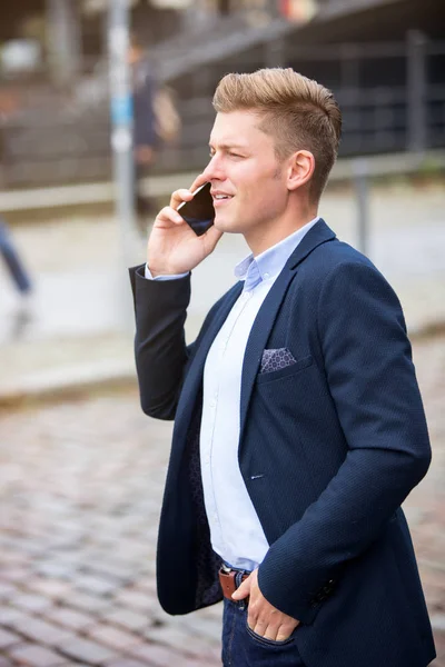 Hombre de negocios parado afuera y hablando por teléfono — Foto de Stock