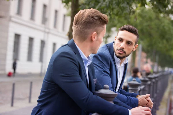 Два бизнесмена стоят снаружи и беседуют — стоковое фото
