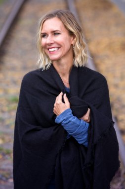 Dışarıda tren rayları üzerinde duran sarışın kadın