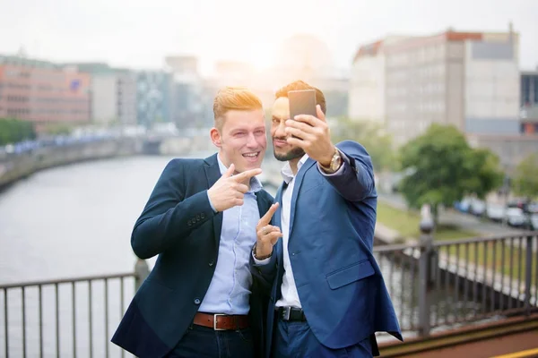 Dois homens de negócios bonitos falando uma selfie — Fotografia de Stock