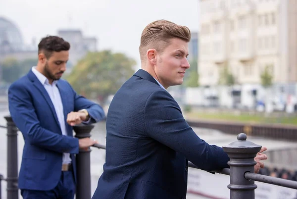 Zwei junge Geschäftsleute stehen draußen und warten — Stockfoto