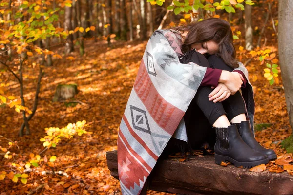 Young sad woman sitting outside in autumn — Stock Photo, Image