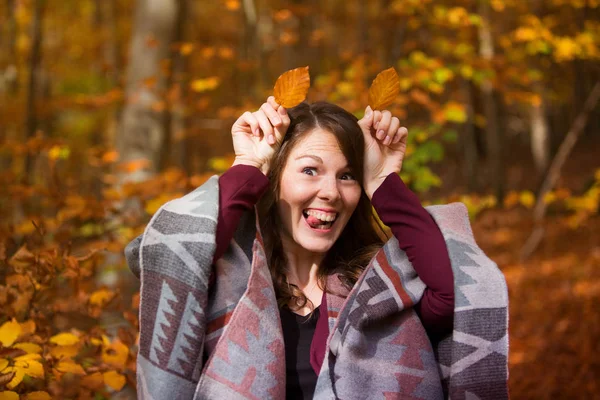 Jovem mulher na floresta segurando folhas para a cabeça — Fotografia de Stock