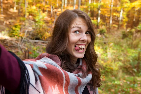 Jovem no parque no outono e tirar uma selfie — Fotografia de Stock