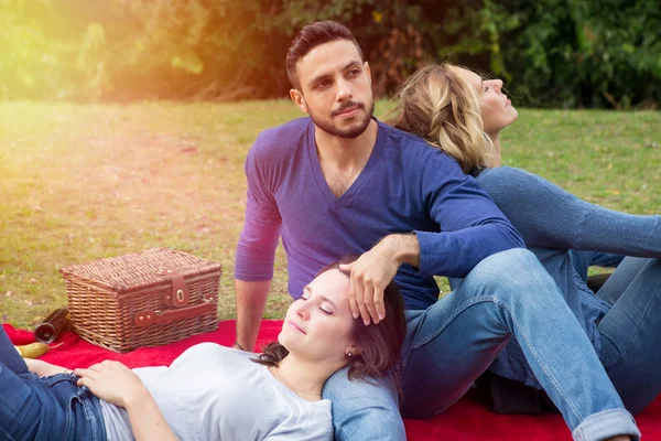 Tre amici che fanno un picnic e si godono il sole — Foto Stock