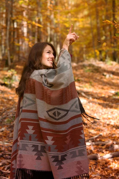 Mulher andando no outono na floresta e apontando para algo — Fotografia de Stock