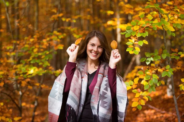 Jovem morena mulher na floresta segurando folhas — Fotografia de Stock