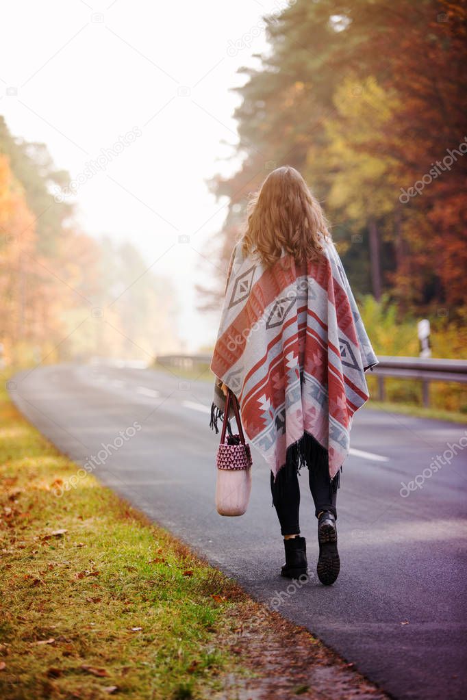 young woman walking on street in autumn