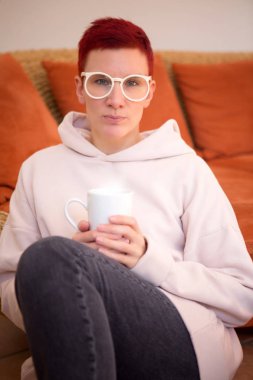 bir fincan holding ile kanepede oturan kadın portresi