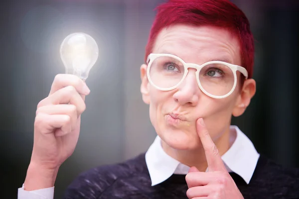 Portret van een vrouw met een gloeiende gloeilamp — Stockfoto