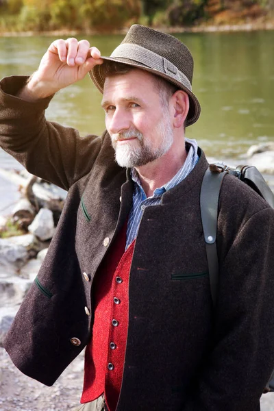 Hombre bavariano en sus 50 años de pie junto al río — Foto de Stock