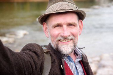 nehir kenarında duran ve bir selfie alarak 50'li Bavyera adam