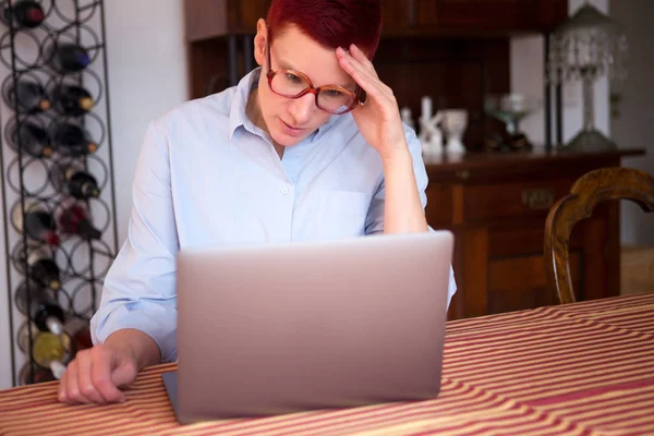 Donna a casa guardando il suo computer portatile — Foto Stock